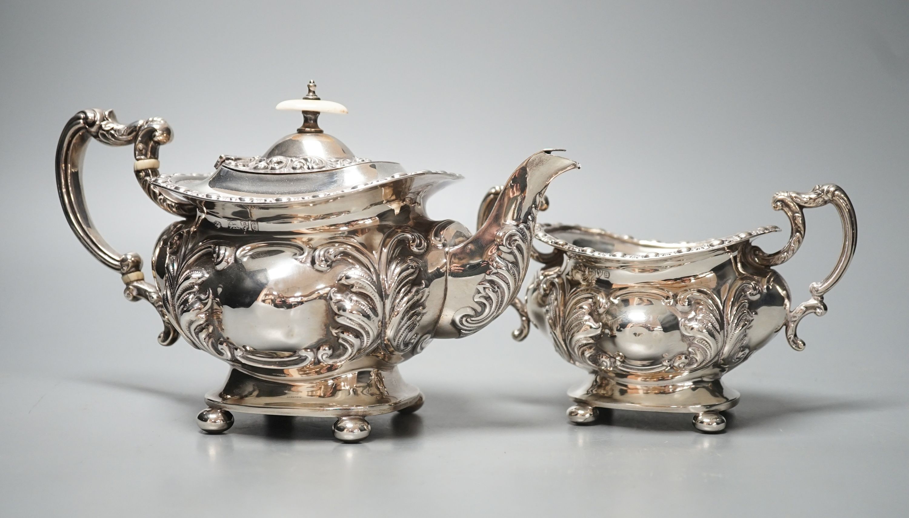 An Edwardian embossed silver teapot and matching sugar bowl, William Aitken, Chester, 1903, gross 21.5oz.